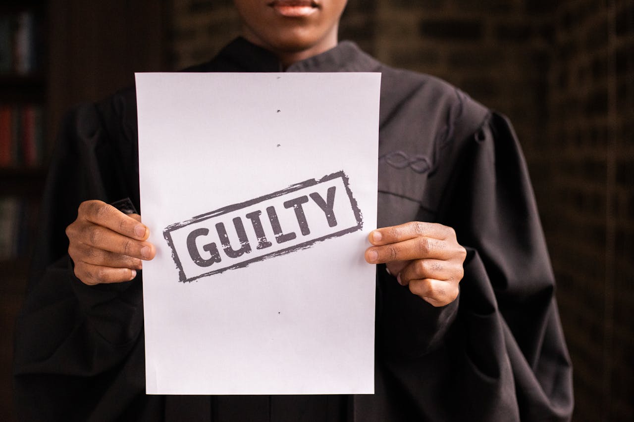 A person holding a sign guilty