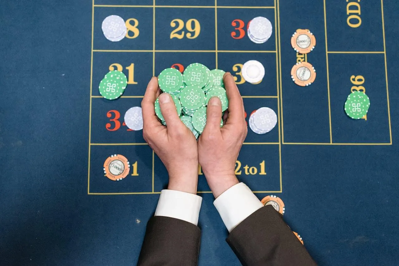 Two hands taking roulette chips